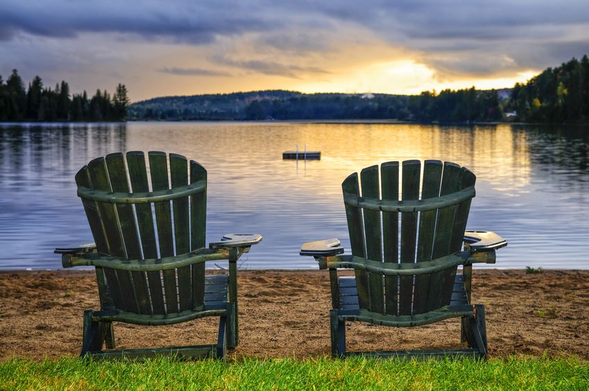 Two Adirondack Chairs on the shore of a lake